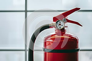 Red fire extinguisher with gauge and hose, symbolizing safety and preparedness