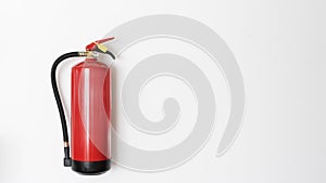 Red fire extinguisher hanging on white wall