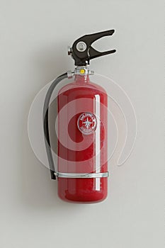 fire extinguisher on white wall, close up