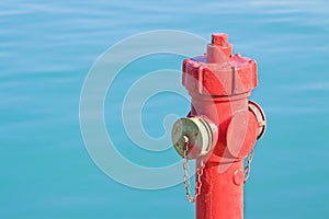 Red fire hydrant against a water background - concept image with