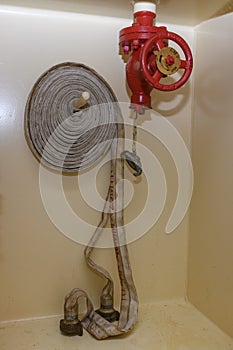 Red fire hydrant with coiled hose. Fire fighting equipment