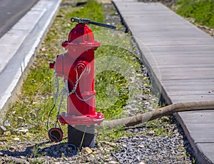 Red fire hydrant with connected hose