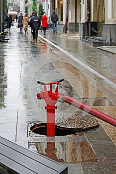 Red fire hydrant with hose in the hatch