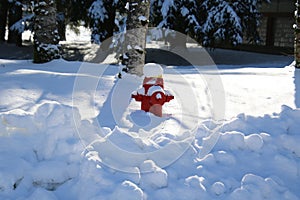 A red fire hydrant partially buried in snow