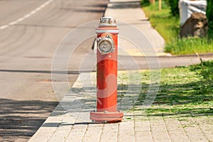 Red fire hydrant standing on the pavement