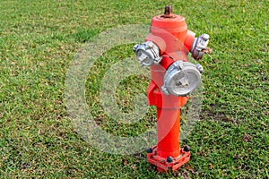 Red fire hydrant stands on a green lawn