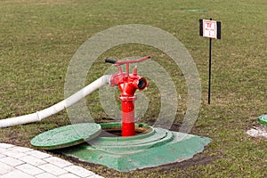 Red fire hydrant stands in manhole