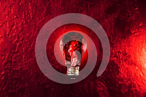 Red fire in the lamp bulb. New idea concept