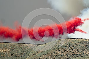 Red Fire Retardant Suspended in Midair After Being Dropped on a Raging Wildfire