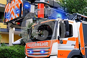 Red fire truck in the courtyard of a multi-storey building arrives on call, emergency 112 concept for a fire in Germany, flashing