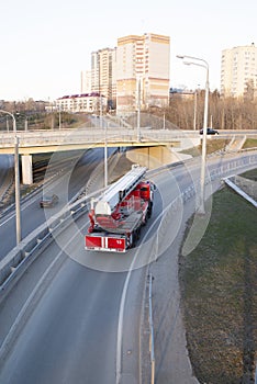 a red fire truck rides on an asphalt road in the city