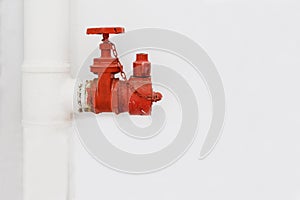 Red firefighting hydrant over the grey wall of staircase. Equipment for connecting firehose. Fire extinguishing system. Manual