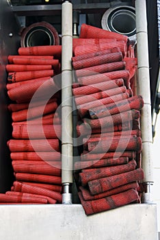 Red firehoses in a truck to be used by firefight.