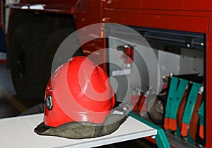 Red fireman helmet near a fire truck
