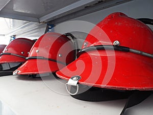 Red fireman helmet prepared on shelf