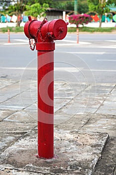 Red fireplug standing alone on footpath