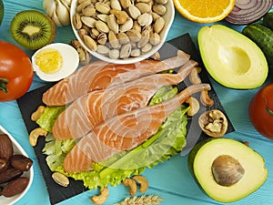Red fish, avocado, nuts on a blue wooden background, healthy food