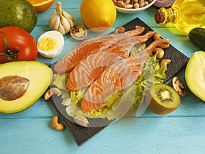 Red fish fillet avocado, fresh nutrition on a black wooden background, healthy food