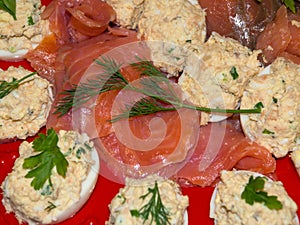 Red fish and stuffed eggs closeup