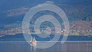 Red Fishing boat in Eide on autumn day on Atlantic Road in Norway