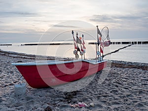 Red fishing boat lying on beach of the Ruegen island at Dranske village