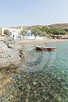 Red fishing boat moored in a sandy Greek island beach