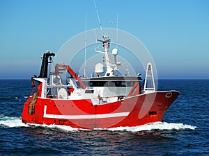 Red Fishing Boat Underway at Sea. photo