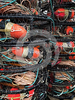 Red fishing buoys and ropes in a stack of crab traps
