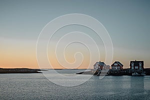 Horizontal photo of red fishing cabins in Trondelag during spring sunset photo