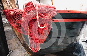 Red fishnet lying blue wooden rowboat