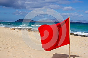 Red flag on beach. Warning sign. Dangerous swim. Safety guard, lifebuoy, lifeguard, life guard. Vacation at ocean.