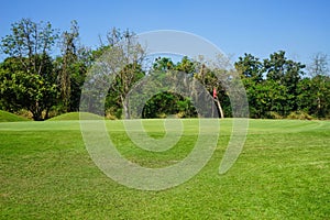 Red flag at the beautiful golf course at the sunrise time. Beautiful golf course in a sunny day. Background evening golf course