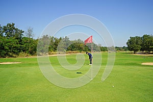 Red flag at the beautiful golf course at the sunrise time. Beautiful golf course in a sunny day. Background evening golf course