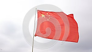 Red flag of China with five golden stars symbolizing Communist Revolution and unity of Chinese people under leadership