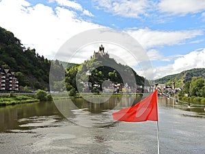 Red flag and Cochem town on Moselle river