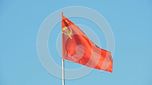 The red flag with the hammer and sickle of the Union of Soviet Socialist Republics USSR is flying in the wind