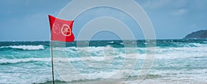 Red flag no swimming here sign at beach in windy day