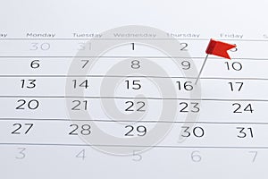 Red flag pin on a calendar closeup. Important date. Place for text.