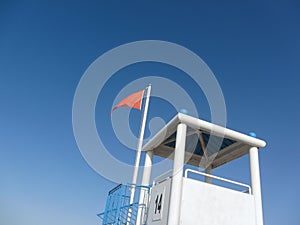 Red flag for rough sea over a lifeguard tower long an Italian be