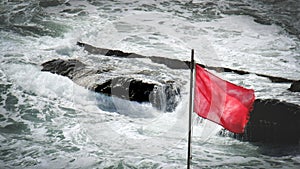 Red flag sea rocks rough storm gale wind alert background photo