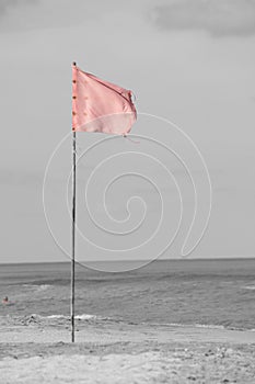 red flag on the seashore indicating bathing is prohibited