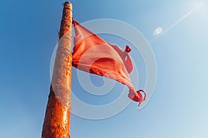 Red flag to develop on the background of blue sky