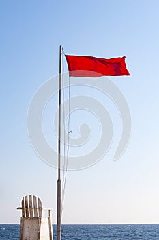 Red flag and white wooden chair on the background of blue sky and red sea, Hurghada, Egypt