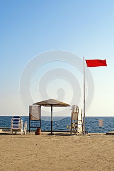 Red flag and white wooden chair on the background of blue sky and red sea, Hurghada, Egypt