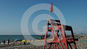 Red flag on a wooden rescue tower. Symbol of danger