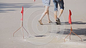 Red flags flutter on coasters and warn of fresh cement on the road. Repair work