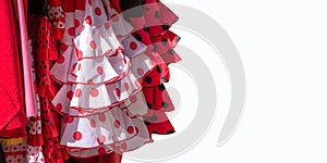 Red flamenco dresses on white background in Seville, Andalusia