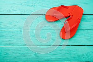 Red flip flops on blue wooden background. Summer holiday. Slippers on the beach. Top view. Mock up. Copy space