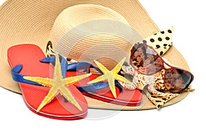 Red flip flops with starfishes, sunglasses and a seashell isola