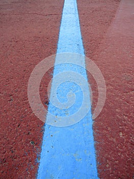 Red floor background with blue painted line. Signals and beacons. Urban asphalt Pattern and texture